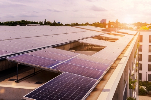 The sun sets on a rooftop solar array.